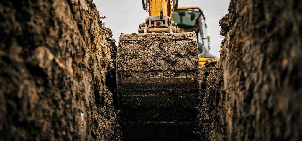 excavator clearing dirt from inside hole